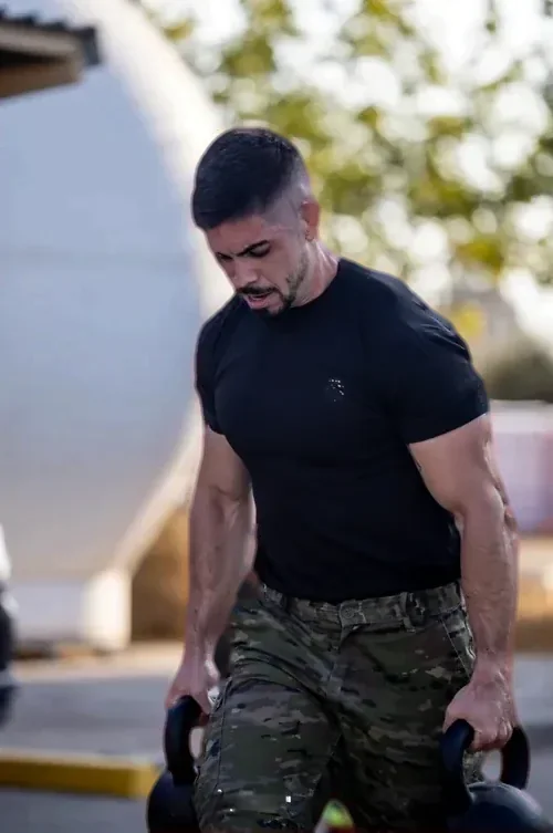 Alex Pérez entrenando con kettlebells y pantalón de camuflaje